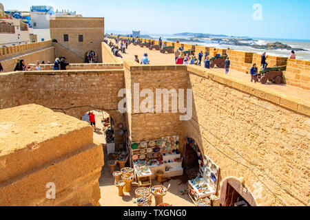 Les touristes grimper les remparts d'Essaouira, Maroc. Canon en laiton ligne les murs et il y a de superbes vues sur l'océan Atlantique. Banque D'Images