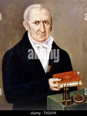 Alessandro Volta, physicien italien. Sur la table sont deux de ses inventions, la pile voltaïque (batterie) sur le côté gauche, et electrophorus, un appareil démontrant la charge électrostatique par induction. Son nom donné à l'unité de différence de potentiel électrique. Banque D'Images