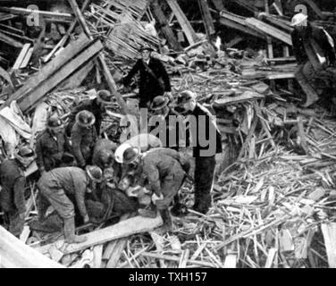 La libération des travailleurs de sauvetage blessé des débris d'un bâtiment détruit par les bombardements allemands : 1940. La Seconde Guerre mondiale. Banque D'Images