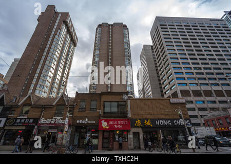 TORONTO, CANADA - LE 14 NOVEMBRE 2018 : Ancienne maisons individuelles entourées par une tour moderne appartement condo la construction de tours sur la rue Queen, dans une zone Banque D'Images