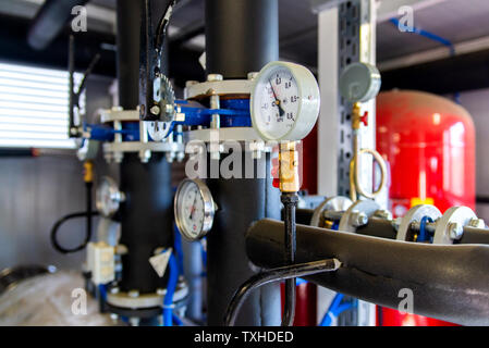 Gros plan du manomètre, mesurer la pression des gaz. Des tuyaux et des distributeurs à l'établissement industriel. Manomètre, instrument de mesure close up sur l'eau chaude, d'huile ou Banque D'Images