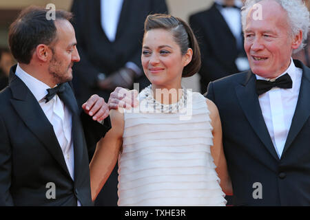 Fabrizio Rongione (L), Marion Cotillard (C) et Jean-Pierre Dardenne arrivent sur les marches du Palais des Festivals avant la projection du film 'Deux jours, une nuit (deux jours, une nuit") lors de la 67 e assemblée annuelle du Festival International du Film de Cannes à Cannes, France le 20 mai 2014. UPI/David Silpa Banque D'Images