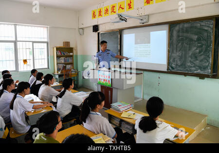 Haikou, province de Hainan en Chine. 25 Juin, 2019. Un policier explique les méfaits de la drogue aux étudiants pendant une activité éducative organisée à Dongying Middle School à venir de la Journée internationale contre l'abus et le trafic illicite de Haikou, province de Hainan en Chine du sud, le 25 juin 2019. La Journée internationale contre l'abus et le trafic illicite est observée le 26 juin chaque année. Crédit : Yang Guanyu/Xinhua/Alamy Live News Banque D'Images