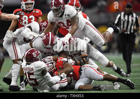 Les Bulldogs de la Géorgie d'utiliser de nouveau Nick Chubb (27) est étouffée par l'Alabama Crimson Tide arrière défensif Ronnie Harrison (15) et de l'Alabama Crimson Tide joueur de ligne défensive Da'Ron Payne (94) au cours de la première moitié de la NCAA College Football Championnat National des éliminatoires de Mercedes-Benz Stadium le 8 janvier 2018 à Atlanta. Photo de David Tulis/UPI Banque D'Images