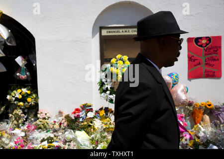 Un homme marche devant un mémorial à l'extérieur de l'Église épiscopale méthodiste africaine Emanuel services suivants le 21 juin 2015 à Charleston, Caroline du Sud. Le 17 juin 2015, neuf personnes ont été tuées à l'intérieur de l'église au cours de l'étude de la Bible. Un suspect, Dylann, Pavillon 21, a été arrêté dans le cadre de la fusillade. Photo par Kevin Liles/UPI Banque D'Images