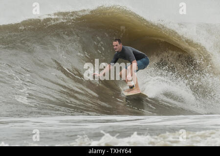 Un surfer rides l'augmentation gonfle comme l'ouragan Florence s'approche de la côte de la Caroline, le 13 septembre 2018 dans la région de Folly Beach en Caroline du Sud. Un ordre d'évacuation obligatoire reste en vigueur pour la côte, mais au moins la moitié des habitants de Charleston sont soupçonnés d'avoir séjourné comme la tempête perd en intensité. Photo de Richard Ellis/UPI Banque D'Images