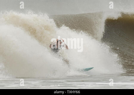 Un surfer rides l'augmentation gonfle comme l'ouragan Florence s'approche de la côte de la Caroline, le 13 septembre 2018 dans la région de Folly Beach en Caroline du Sud. Un ordre d'évacuation obligatoire reste en vigueur pour la côte, mais au moins la moitié des habitants de Charleston sont soupçonnés d'avoir séjourné comme la tempête perd en intensité. Photo de Richard Ellis/UPI Banque D'Images