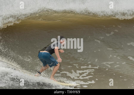 Un surfer rides l'augmentation gonfle comme l'ouragan Florence s'approche de la côte de la Caroline, le 13 septembre 2018 dans la région de Folly Beach en Caroline du Sud. Un ordre d'évacuation obligatoire reste en vigueur pour la côte, mais au moins la moitié des habitants de Charleston sont soupçonnés d'avoir séjourné comme la tempête perd en intensité. Photo de Richard Ellis/UPI Banque D'Images