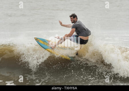Un surfer rides l'augmentation gonfle comme l'ouragan Florence s'approche de la côte de la Caroline, le 13 septembre 2018 dans la région de Folly Beach en Caroline du Sud. Un ordre d'évacuation obligatoire reste en vigueur pour la côte, mais au moins la moitié des habitants de Charleston sont soupçonnés d'avoir séjourné comme la tempête perd en intensité. Photo de Richard Ellis/UPI Banque D'Images