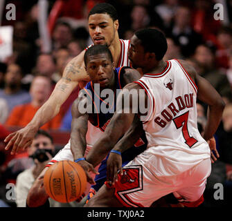 New York Knicks' Nate Robinson, centre, passe le ballon que Chicago Bulls' Tyson Chandler, dos, et Ben Gordon (7) défendre au cours du quatrième trimestre le 18 janvier 2006, à Chicago. Les Bulls a gagné 106-104. (Photo d'UPI/Brian Kersey) Banque D'Images