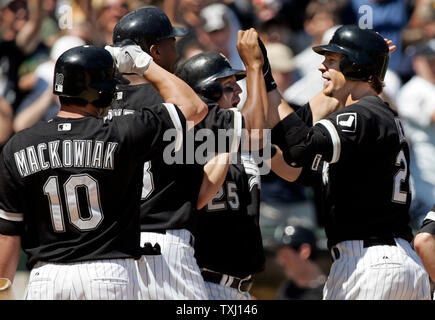 White Sox de Chicago de troisième but Joe Crede (24), droit à la maison, est félicité par coéquipiers plaque Rob Mackowiak (10), Jermaine Dye (23) et Jim Thome (25) après avoir frappé un grand chelem de releveur Tchad Houston Astros Qualls pour égaliser le match à l'US Cellular Field, à Chicago, Illinois le 24 juin 2006. Les White Sox défait les Astros 6-5 en 10 manches. (UPI Photo/Mark Cowan) Banque D'Images