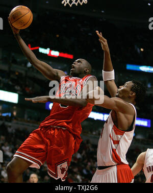 Des Chicago Bulls, Luol Deng du Soudan (L) va jusqu'à un tir que Toronto Raptors' Chris Bosh défend au cours du deuxième trimestre à Chicago le 13 février 2007. (Photo d'UPI/Brian Kersey) Banque D'Images
