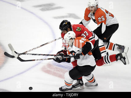 L'aile gauche des Blackhawks de Chicago Dustin Byfuglien (33) tente de mettre la rondelle de glace entre les Flyers de Philadelphie Danny Briere (48) et Matt Carle (25) au cours de la troisième période de jeu 2 de la finale de la Coupe Stanley de 2010 à l'United Center de Chicago, le 31 mai 2010. Les Blackhawks défait les Flyers 2-1 de prendre un plomb 2-0 dans le meilleur des sept séries. (UPI Photo/Mark Cowan) Banque D'Images