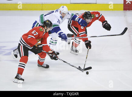 Blackhawks de Chicago Michael Frolik aile gauche (L) de la République tchèque le défenseur Nick Leddy (R) et l'aile gauche des Canucks de Vancouver Chris Higgins rendez pour la rondelle au cours de la première période de la finale de conférence de l'ouest de la LNH à l'United Center de Chicago le 17 avril 2011. UPI/Brian Kersey Banque D'Images