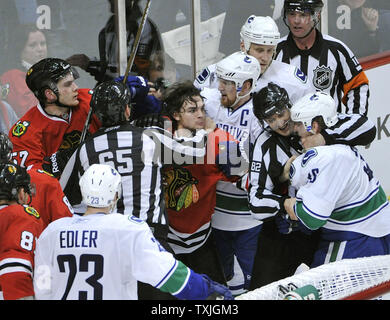 L'aile gauche des Blackhawks de Chicago Michael Frolik (C) de la République tchèque est en elle avec l'aile droite des Canucks de Vancouver Jannik Hansen (R) à la fin de la troisième période de jeu 3 de la Conférence de l'ouest de la LNH coupe à l'United Center de Chicago le 17 avril 2011. Les Canucks a gagné 3-2 et laisse le meilleur des sept séries 3-0. UPI/Brian Kersey Banque D'Images