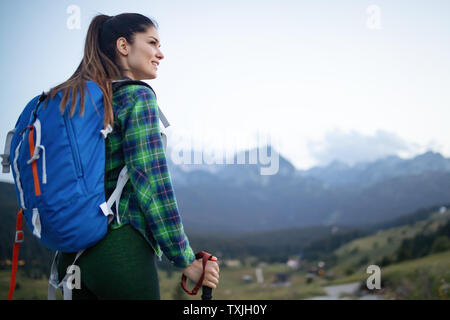 Hiker with backpack se détendre au sommet d'une montagne et profiter de vue sur la vallée Banque D'Images