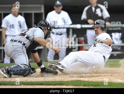 White Sox de Chicago's Paul Konerko (R) cours des Tigers de Detroit catcher Alex Avila sur un triple RBI touchés par A. J. Pierzynski durant la sixième manche au U.S. Cellular Field le 13 avril 2012 à Chicago. UPI/Brian Kersey Banque D'Images