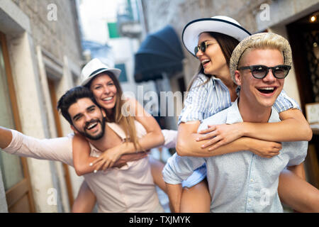 Happy friends enjoying piggyback tandis que les sites touristiques de la ville. Banque D'Images