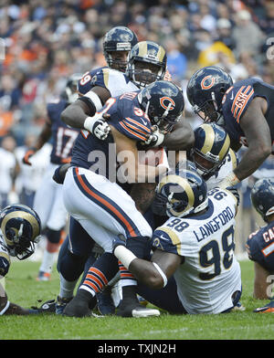 Ours de Chicago d'utiliser de nouveau Kahlil Bell (L) est abordé par Saint Louis Rams défensive fin William Hayes (haut), la défense s'attaquer Kendall Langford (98) et de défense s'attaquer Jermelle Cudjo pour aucun gain au cours du deuxième trimestre à Soldier Field, le 23 septembre 2012 à Chicago. UPI/Brian Kersey Banque D'Images