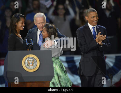 Le président américain Barack Obama salue en tant que vice-président Joe Biden hugs Obama's children Malia et Sasha (L) au cours de la célébration de la victoire à la McCormick Place de Chicago le 6 novembre 2012. Obama est réélu vaincre challenger républicain Mitt Romney. UPI/Kevin Dietsch Banque D'Images