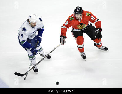 L'aile droite des Canucks de Vancouver Zack Kassian (L) et le défenseur des Blackhawks de Chicago Nick Leddy rendez pour la rondelle, durant la première période, à l'United Center de Chicago le 19 février 2013. Les Blackhawks ont remporté 4-3 dans une fusillade. UPI/Brian Kersey Banque D'Images