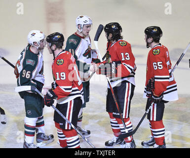 Jonathan Toews, des Blackhawks de Chicago (19), Daniel Carcillo (13) et Andrew Shaw (65) serrer la main avec du Wild du Minnesota Pierre-Marc Bouchard (96) et Zach Parise après Match 5 de la finale de conférence de l'ouest de la LNH lors de l'éliminatoire de la Coupe Stanley 2013 au United Center de Chicago le 9 mai 2013. Les Blackhawks ont remporté 5-1, battant le Wild 4-1 dans le meilleur des sept séries. UPI/Brian Kersey Banque D'Images