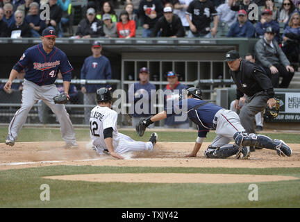 White Sox de Chicago's Conor Gillaspie (L) cours des Twins du Minnesota catcher Kurt Suzuki sur un sacrifice fly touchés par Adam Dunn au cours de la troisième manche du jour de l'ouverture de leur jeu à U.S. Cellular Field le 31 mars 2014 à Chicago. UPI/Brian Kersey Banque D'Images