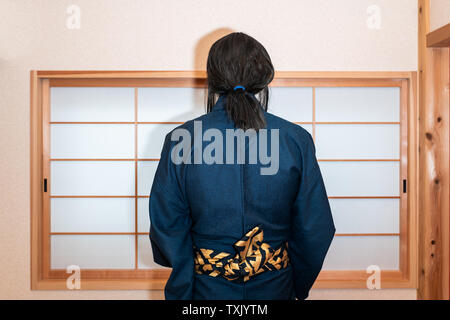 Maison traditionnelle japonaise avec porte coulissante fenêtre avec retour de l'homme en costume kimono avec ceinture ceinture obi permanent Banque D'Images