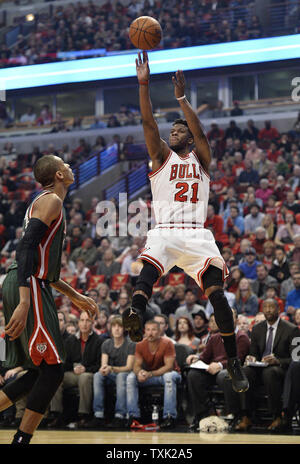 Chicago Bulls guard Jimmy Butler (R) shoots comme Milwaukee Bucks avant Giannis Antetokounmpo défend au cours du premier trimestre de match 5 du premier tour des playoffs NBA à l'United Center le 27 avril 2015 à Chicago. Photo de Brian Kersey/UPI Banque D'Images