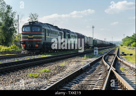 Les trains de marchandises sur la voie. La locomotive tire les wagons de différents types. Banque D'Images