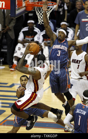 Avant Miami Heat LeBron James tire contre les gardiens des Bobcats Gerald Henderson, gauche, et Gerald Wallace (3) dans la deuxième moitié d'un match de basket-ball NBA à Charlotte, Caroline du Nord le 4 février 2011. Miami a remporté 109-97. UPI/Nell Redmond Banque D'Images