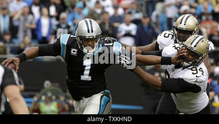 Quarterback Carolina Panthers Cam Newton est saccagée par New Orleans Saints extrémités défensives Cameron Jordan (94) et Tyrunn Walke au deuxième trimestre à la Bank of America Stadium à Charlotte, Caroline du Nord le 22 décembre 2013. UPI/Nell Redmond . Banque D'Images