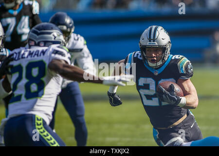 Panthers running back Christian McCaffrey, droit, recherche des prix en cours contre Seattle Seahawks Justin Coleman évoluait dans la première moitié d'un jeu de football américain NFL à Charlotte, Caroline du Nord le 25 novembre 2018. Photo par Nell Redmond/UPI. Banque D'Images