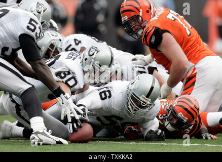 Oakland Raiders humains Derrick Burgess (56), Stuart Schweigert (30) et Thomas Howard (53) pour rejoindre un fumble par active dans les années 1960 Rudi Johnson (32), Andrew Whitworth (77) ressemble à au Stade Paul Brown à Cincinnati le 10 décembre 2006. (UPI Photo/Mark Cowan) Banque D'Images