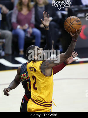 Cleveland Cavaliers' LeBron Kyrie Irving met en place une balle pendant qu'elle a défendu par Tim Hardaway, fils des Atlanta Hawks au cours de la seconde moitié au Quicken Loans Arena de Cleveland le 7 avril 2017. Photo par Aaron Josefczyk/UPI Banque D'Images