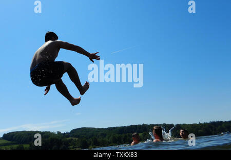 Essen, Allemagne. 25 Juin, 2019. Un adolescent saute dans l'eau à la plage de baignade en mer au lac Baldeney. Crédit : Bernd Thissen/dpa/Alamy Live News Banque D'Images