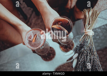 Date romantique les amoureux se tenant la main. à la table. Cocktail sur l'arrière-plan. Concept d'amour. Bouquets de lavande séchée sur l'arrière-plan Banque D'Images