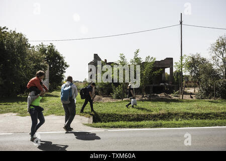 Réfugiés syriens passe devant une maison abandonnée à Tovarnik, Croatie le 19 septembre 2015 . Photo par Zavalli Achille/UPI Banque D'Images