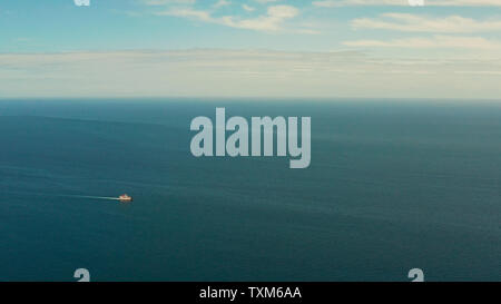 Petit traversier pour passagers en croisière dans la mer bleu ouvert contre le ciel bleu avec des nuages, vue aérienne. Seascape : ésistances ferry boat dans les eaux philippines, Mindanao Banque D'Images