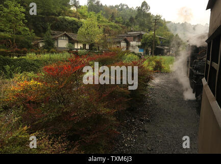 Un train à vapeur passager chugs lentement après un petit village près de Jiayang, une petite ville de montagne dans la province du Sichuan, le 8 avril 2016. Bien que bénéficiant de la plus longue et la plus moderne du système ferroviaire à grande vitesse avec plus de 19 000 km de voies, la Chine est également le dernier tournant passager à voie étroite de train à vapeur. Construit en 1958, le chemin de fer Jiayang a été construit pour transporter le charbon le long d'une piste de 13 km en utilisant des moteurs à vapeur construit dans les années 1950. Les mêmes moteurs sont encore en usage. Photo par Stephen Shaver/UPI Banque D'Images