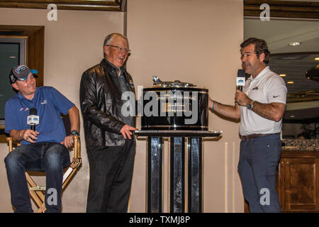 Chef de l'équipe de Mike Wheeler (à gauche) montres comme NFL Hall of Fame Coach et propriétaire de l'équipe NASCAR Joe Gibbs (centre) reçoit le trophée de la Daytona propriétaires Président Joie Chitwood le matin après avoir remporté le Daytona 500 à Daytona International Speedway le 22 février 2016 à Daytona, en Floride. Photo par Edwin Locke/UPI Banque D'Images