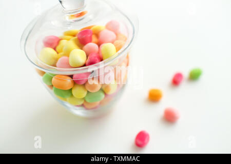 Close up of glass jar avec gouttes de bonbons colorés Banque D'Images