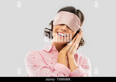 Happy young woman in pajama et les yeux masque de sommeil Banque D'Images