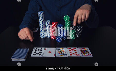 Close up of young man poker player doigt de combinaison de cartes et de jetons à la table de casino. Gagnant du tournoi de jeu succès c Banque D'Images