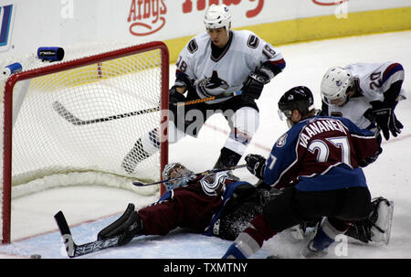 Le gardien David Aebischer Colorado Avalanche (L) s'étend sur la glace faire une sauvegarde contre Ryan Kesler des Canucks de Vancouver cener (R) et l'aile droite Richard Park (deuxième à gauche) lors du Pepsi Center de Denver le 27 novembre 2005. Le défenseur Ossi Vaananen Avalanche se déplace dans de se défendre. Colorado a battu 6-2 à Vancouver. (Photo d'UPI/Gary C. Caskey) Banque D'Images