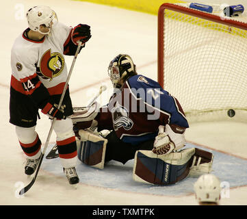 L'aile droite des Sénateurs d'Ottawa Patrick Eaves (L) aide sur un but contre l'Avalanche du Colorado le gardien Vitaly Kolesnik (R) dans la troisième période à la Pepsi Center de Denver, Colorado, le 12 décembre 2005. L'objectif était le but gagnant inscrit par Daniel Alfredsson des Sénateurs les sénateurs que l'Avalanche a battu 6-2. Banque D'Images