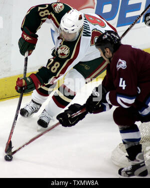 Colorado Avalanche le défenseur Rob Blake (R) s'arrête au centre du Wild du Minnesota Todd White derrière le net Avalanche au Pepsi Center de Denver le 28 février 2006. Colorado a battu Minnesota 4-2. (Photo d'UPI/Gary C. Caskey) Banque D'Images