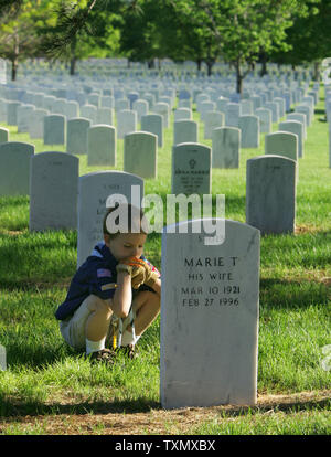 Louveteau Riley Sutton,8, s'accroupit pour regarder une tombe pendant le week-end du Memorial Day au Fort Logan National Cemetery à Denver le 27 mai 2006. Environ 300 Scouts louveteaux bénévoles et des groupes de scouts placé des drapeaux américains sur 87 000 endroits au cimetière. Cimetière national de Fort Logan a été créé en 1889 et a été nommé d'après le général John A. Logan, qui a émis l'Ordonnance générale no 11 qui a mis sur pied le 30 mai Jour de décoration qui plus tard est devenu une fête nationale appelée le jour du Souvenir. (Photo d'UPI/Gary C. Caskey) Banque D'Images