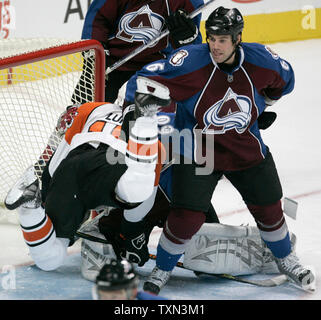 Suspendu Les Flyers de Philadelphie aile droite Joffrey Jupul (L) plonge dans Colorado Avalanche gardien Jose Theodore (obscurci) en tant que joueur d'Avalanche Jeff doigt monte la garde au cours de la deuxième période à la Pepsi Center à Denver le 7 décembre 2007. (Photo d'UPI/Gary C. Caskey) Banque D'Images