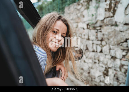 Portrait tête hors de la fenêtre de voiture Banque D'Images